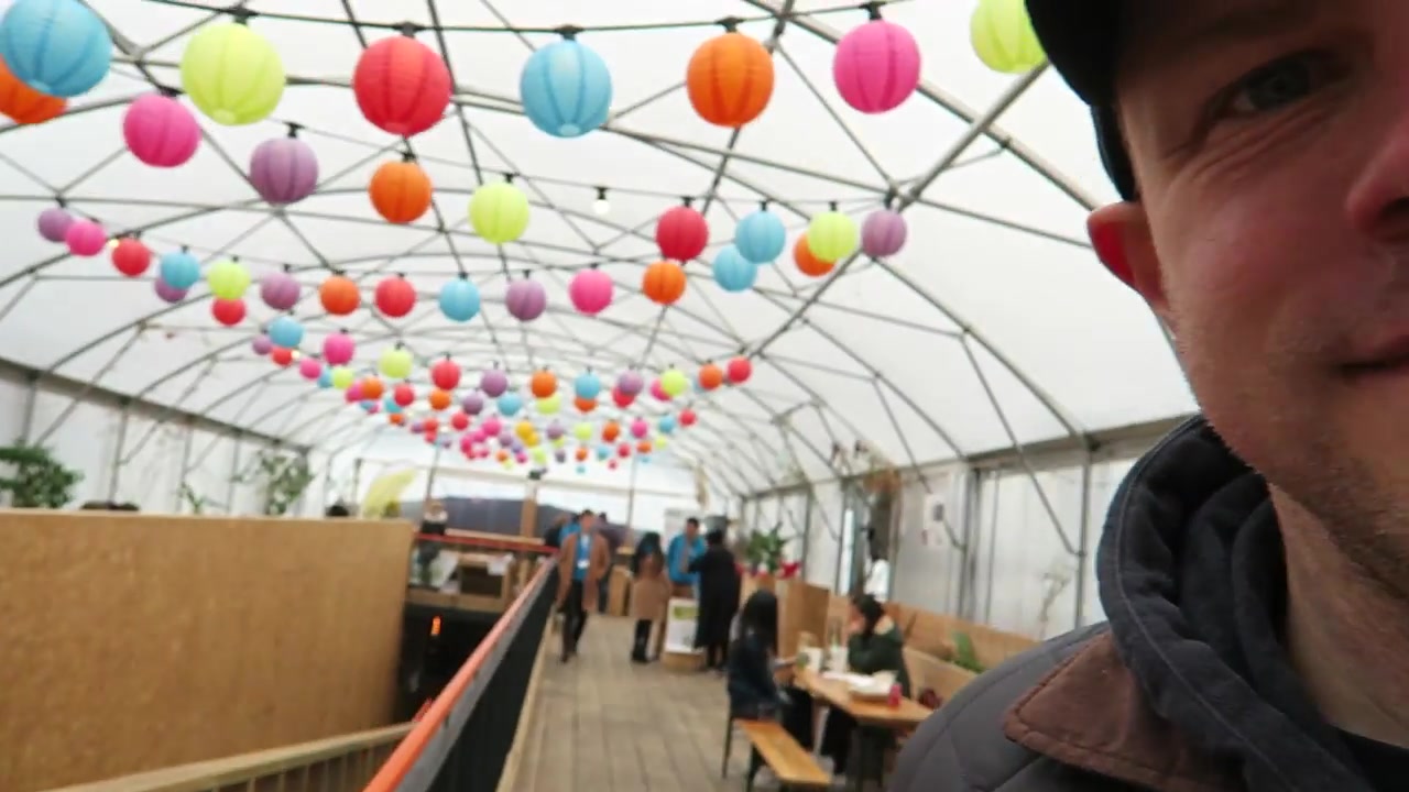 Covered Greenhouse seating area with colourful lanterns at Pop Brixton