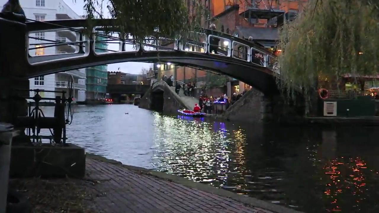 A footbridge and boats on the canal at Camden Lock as the light fades.