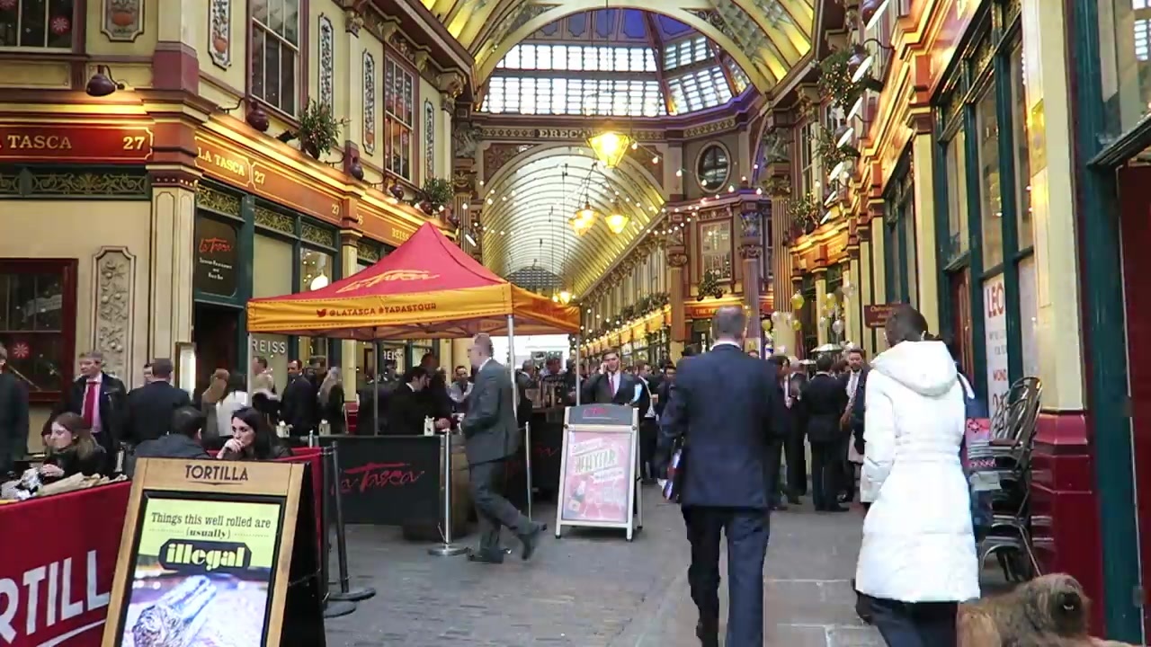 People and food stall in a decorated Leadenhall Market passage