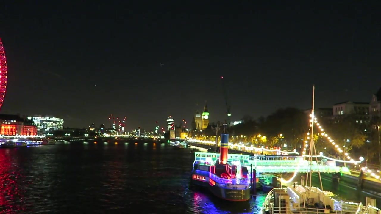 Illuminated boat and riverside buildings on the Thames at night in December 2015
