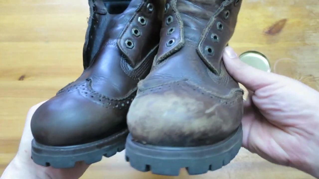 Treated dark leather boot held beside an untreated boot with a pale toe