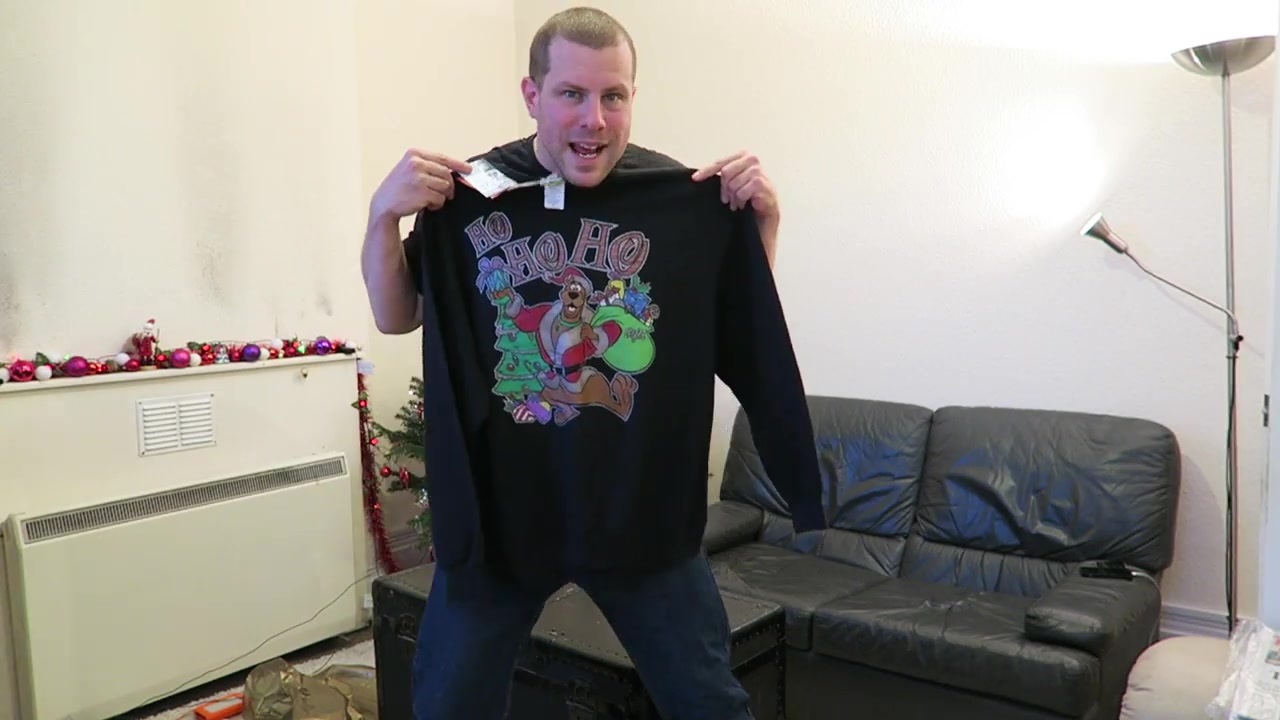 Barry holds up a black Scooby-Doo Christmas jumper after shopping in Camden.
