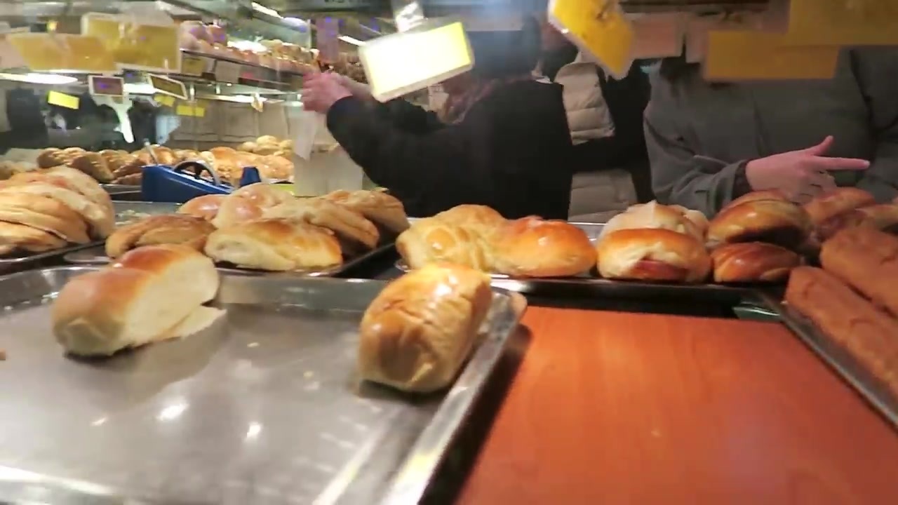 Baked buns displayed on trays in a Chinatown bakery