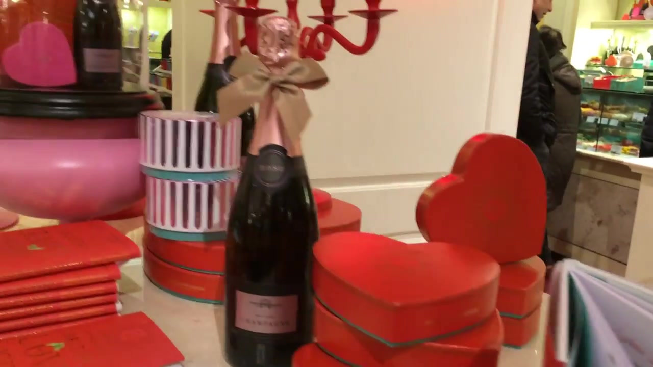Champagne bottle beside heart-shaped red gift boxes at Fortnum and Mason