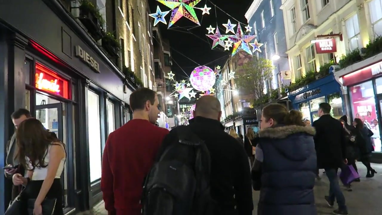 Coloured star decorations above shoppers on Carnaby Street