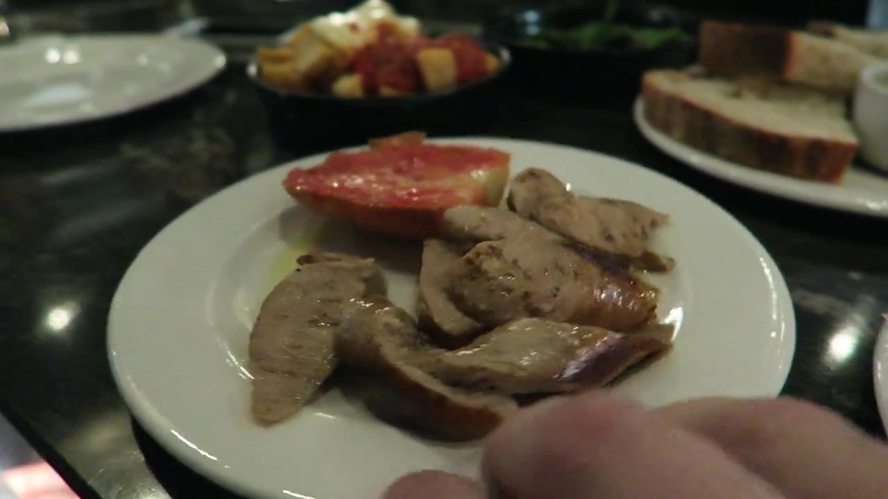 Sliced sausages and tomato bread on a white plate at José Pizarro.