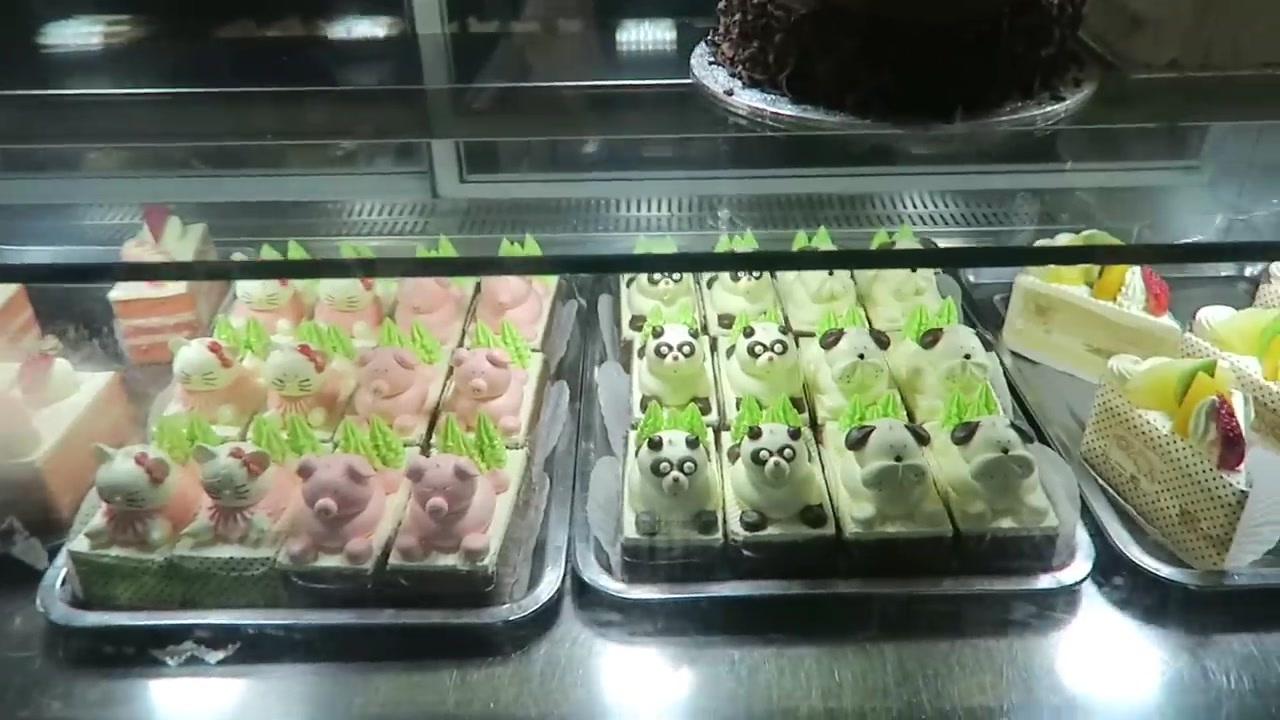 Character-shaped cream decorations on small sponge cakes in Chinatown