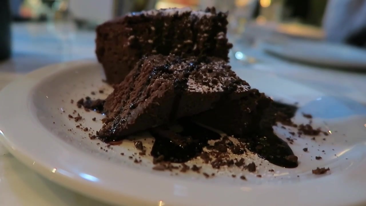 Chocolate dessert and crumbs served on a white plate