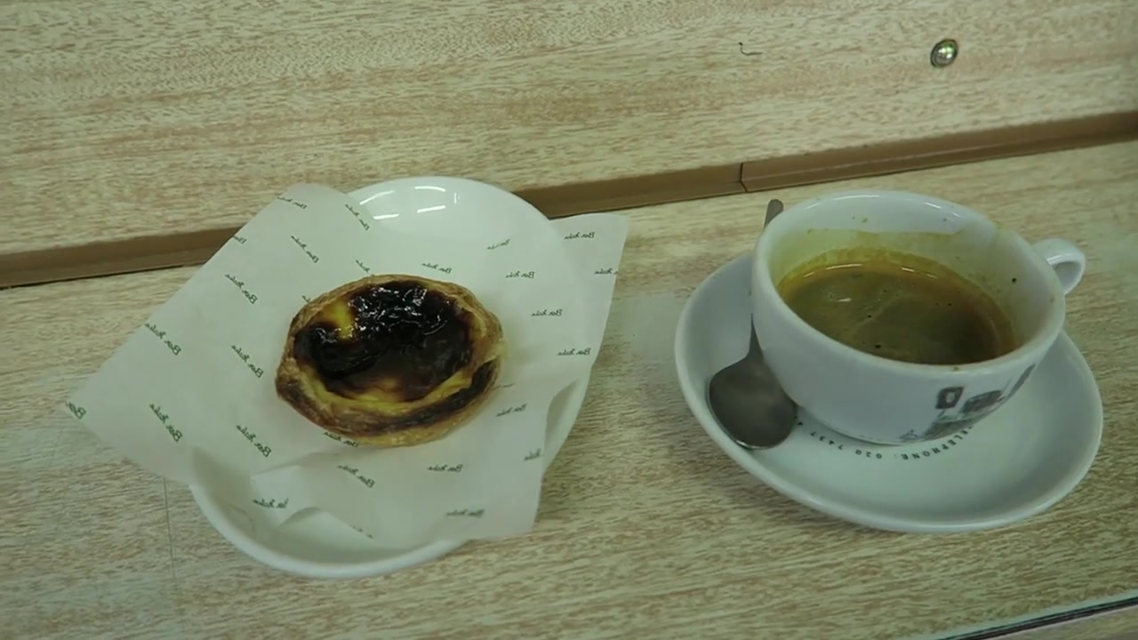 Espresso cup beside a custard tart on the counter at Bar Italia
