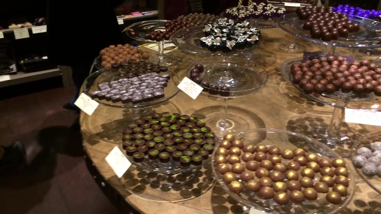 Assorted chocolates displayed on a round wooden table at Paul A Young