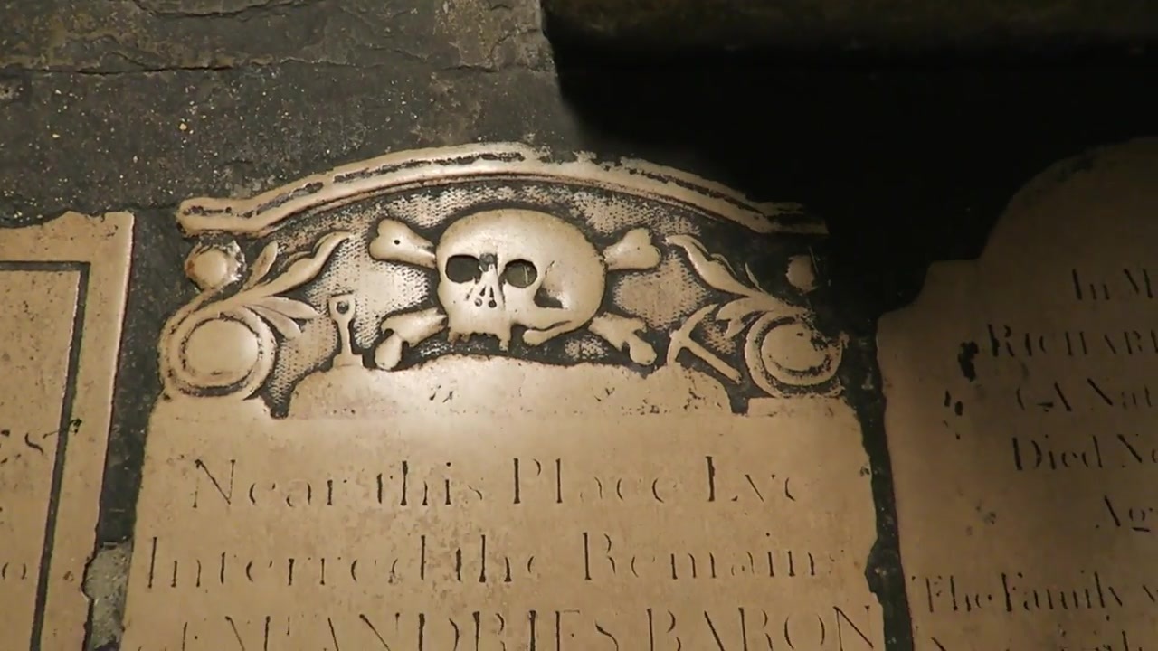 Historic memorial stone with a carved skull motif in the crypt at St Martin-in-the-Fields.