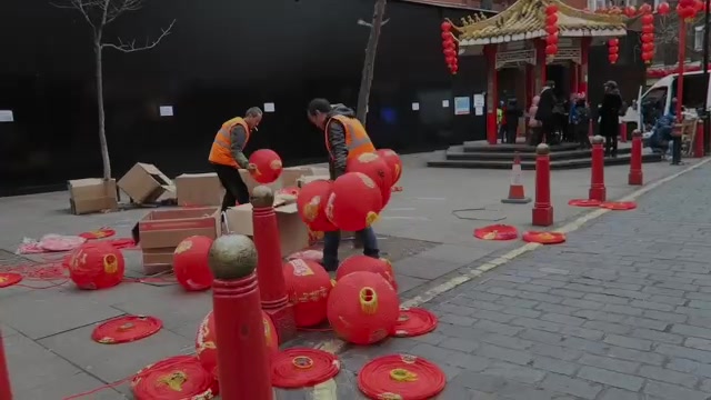 Red lanterns and boxes laid out on the pavement while workers prepare the Chinatown decorations.