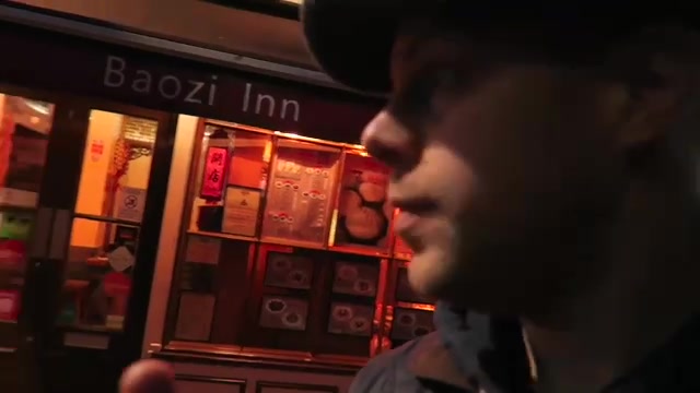Barry beside the illuminated Baozi Inn restaurant frontage during his 2016 Chinatown visit.
