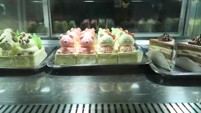 Animal-shaped cream cakes arranged in a lit bakery display in Chinatown.