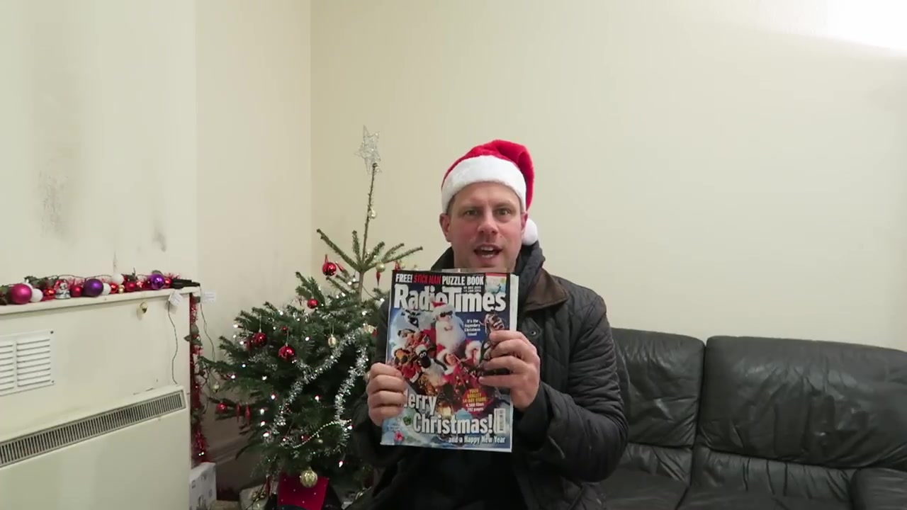 Robert holding the Christmas Radio Times beside his Christmas tree in 2015.
