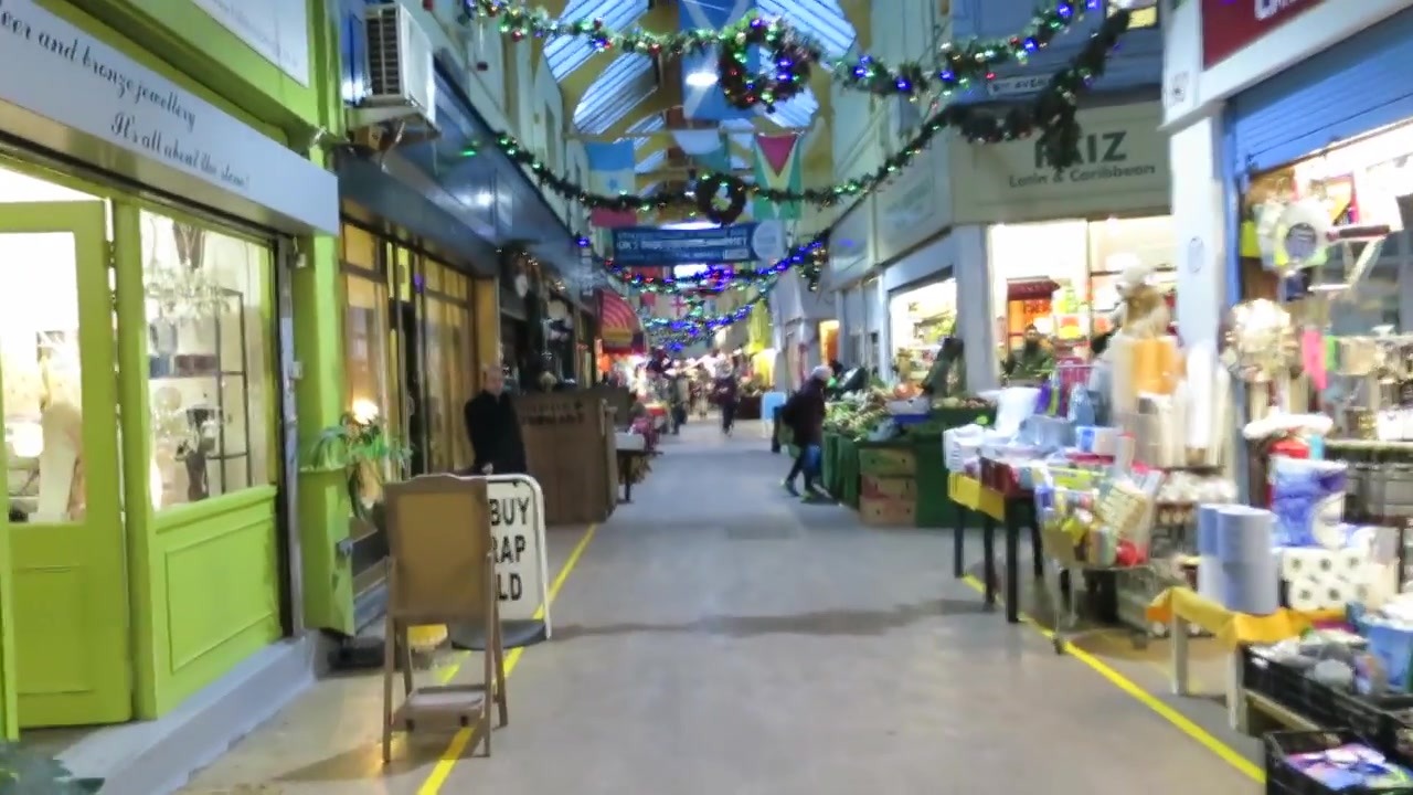 Covered Brixton Village arcade with market stalls and hanging decorations