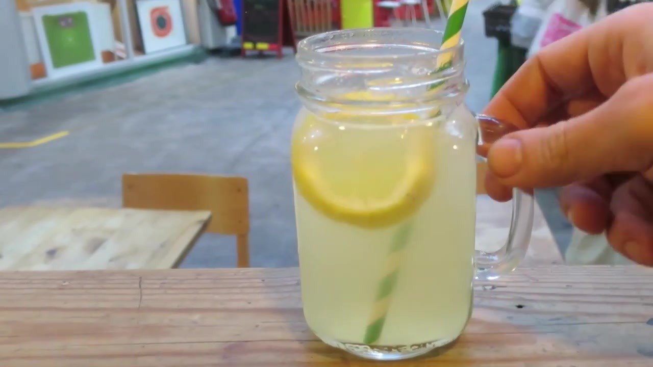 Homemade lemonade served in a handled jar beside the market arcade