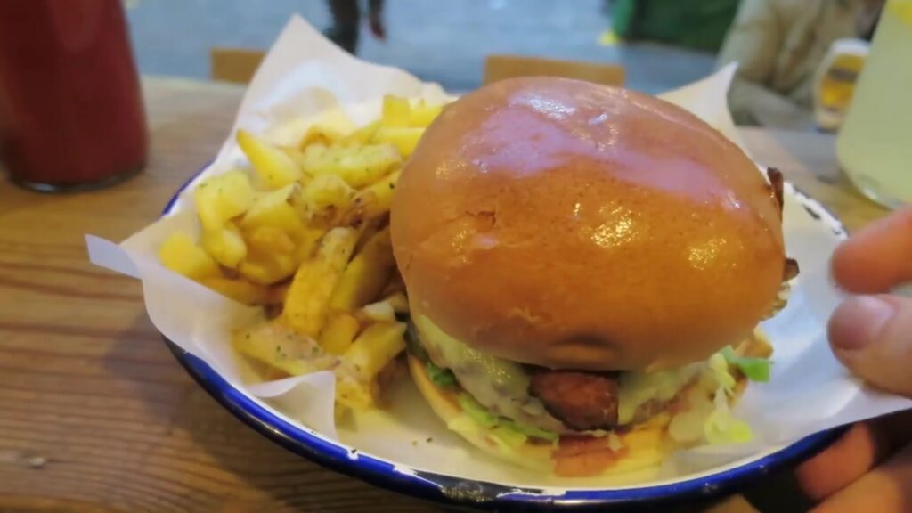Honest beef burger with chips on a blue-rimmed enamel plate