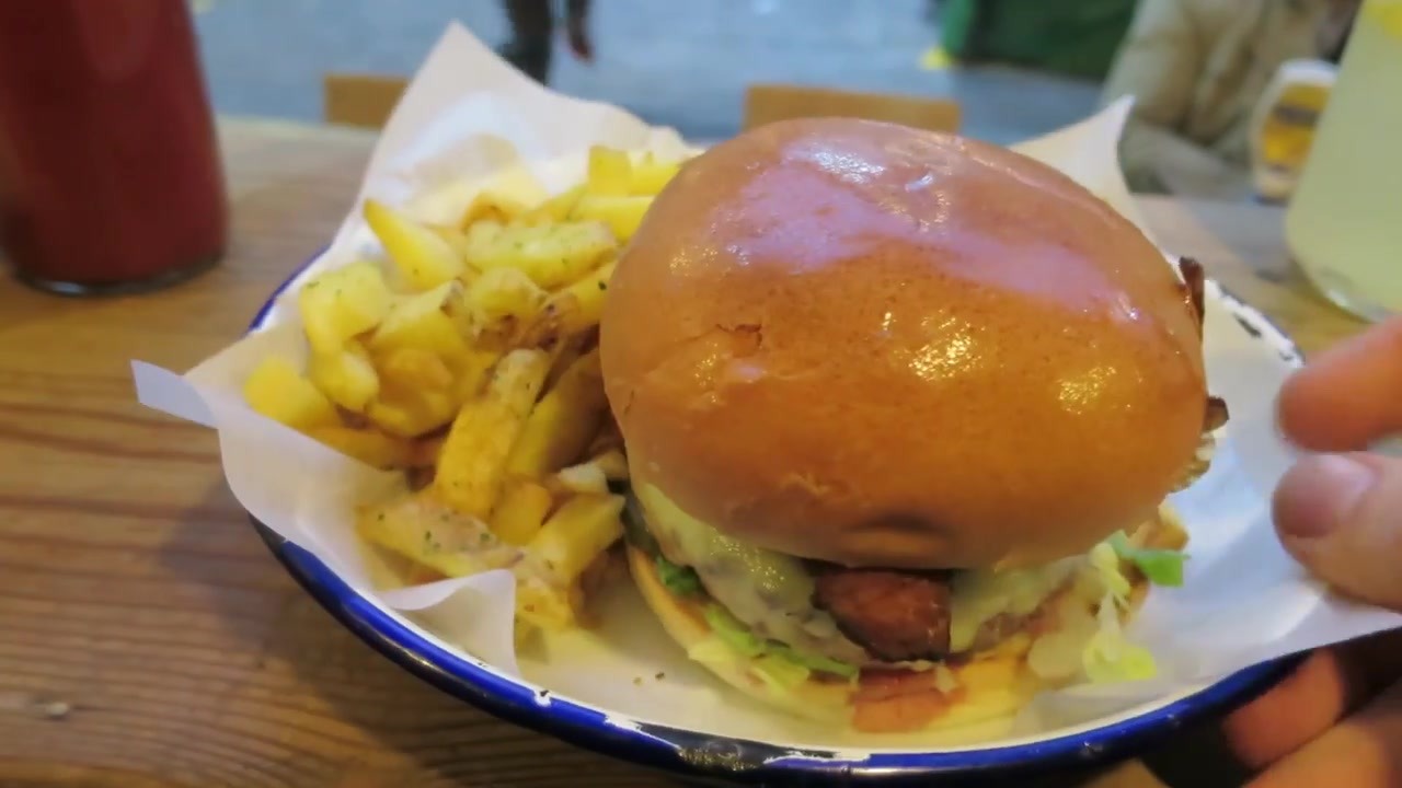 Honest beef burger with chips on a blue-rimmed enamel plate