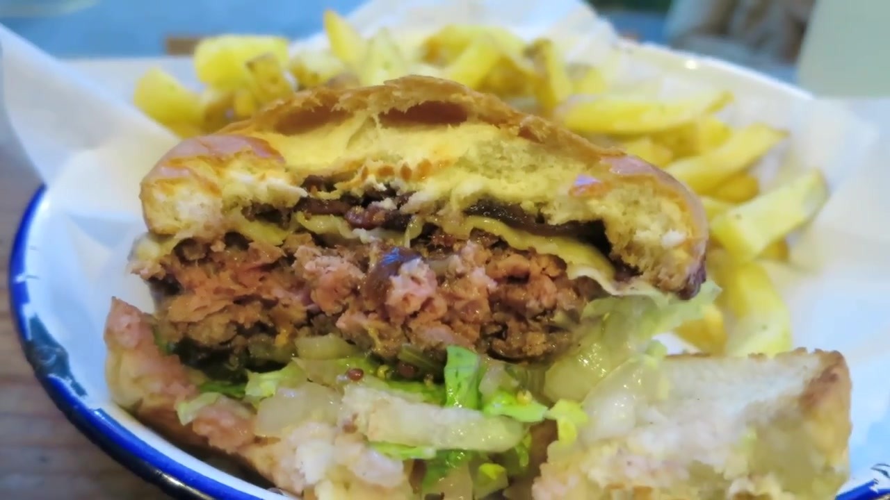 Bitten Honest burger showing beef, cheddar, bacon, pickles and lettuce