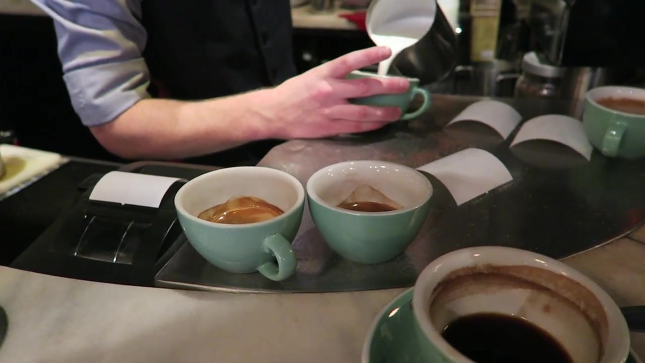 Coffee in pale green cups on the marble bar at Jackson & Rye Soho.