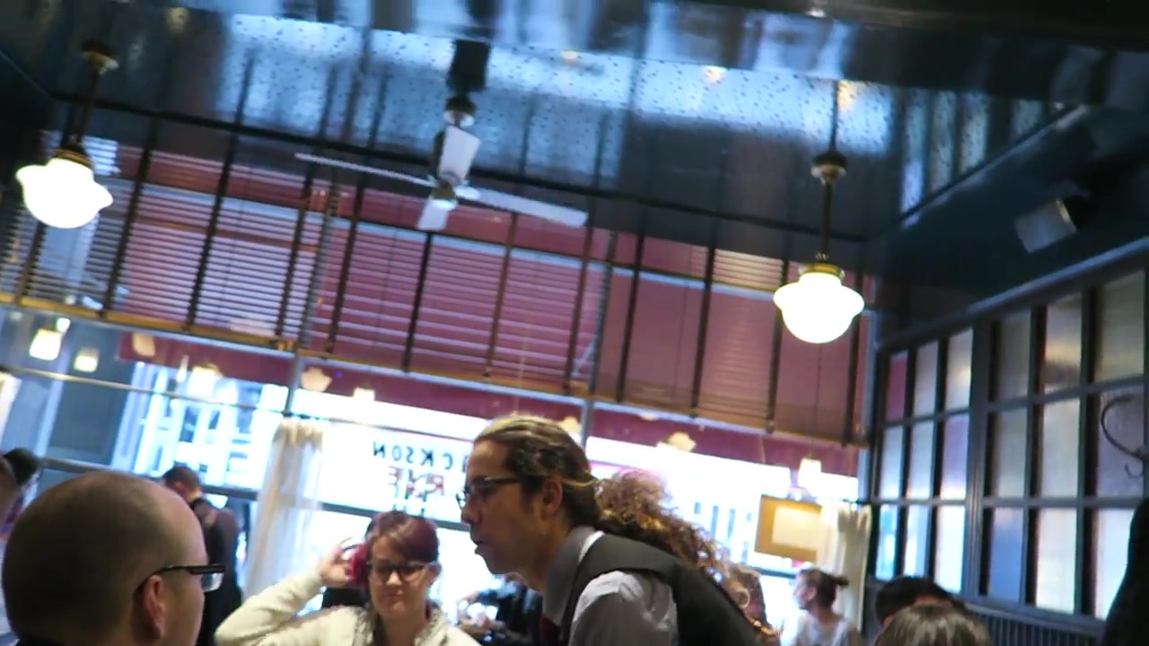 Diners seated by the windows beneath red blinds at Jackson & Rye Soho.