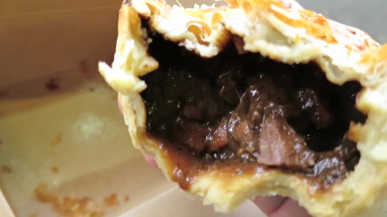 Bitten Shamrock pie with dark steak filling and golden pastry