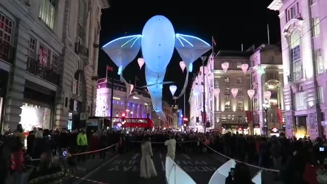 Blue illuminated flying sculpture above the crowds on Piccadilly at Lumiere London 2016