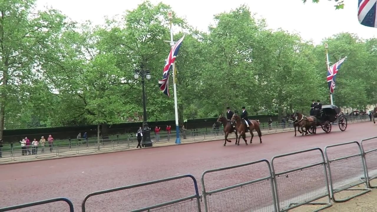 Horse-drawn carriage and mounted escorts passing along The Mall
