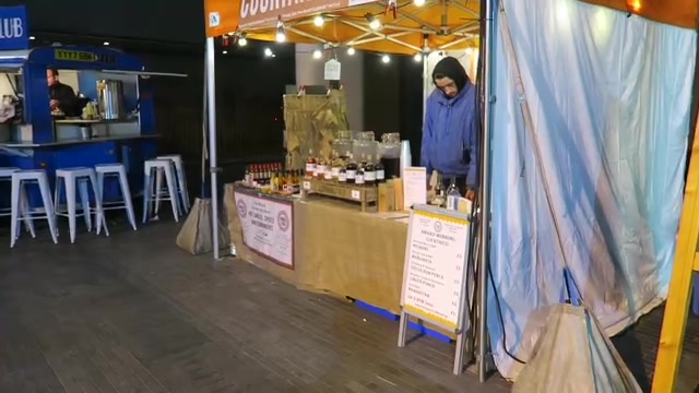 The cocktail stall illuminated at Southbank Centre Market after dark.
